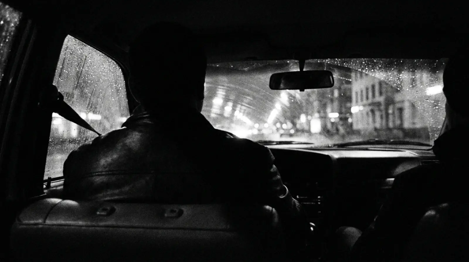 Intérieur d'une berline la nuit, le conducteur en silhouette